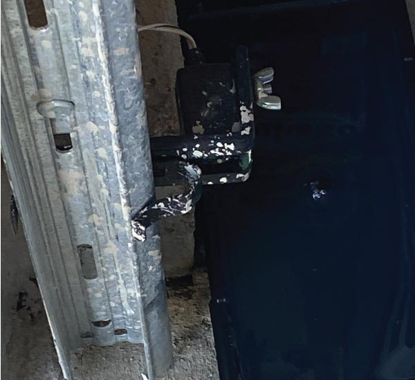 Diagram illustrating the proper side-by-side alignment of the sending and receiving infrared photo eyes on the garage door track.