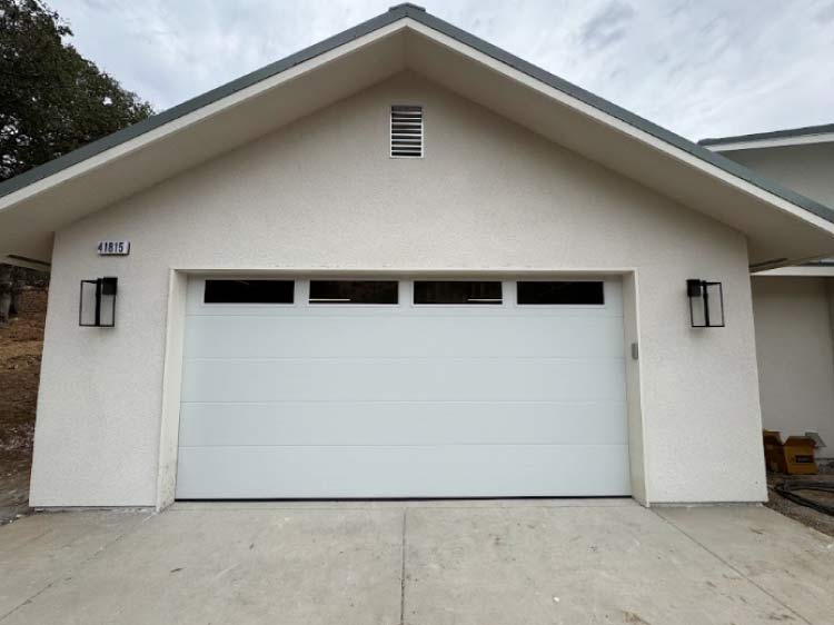 A clean, modern white garage door installation with window inserts completed by Browns Garage Door.